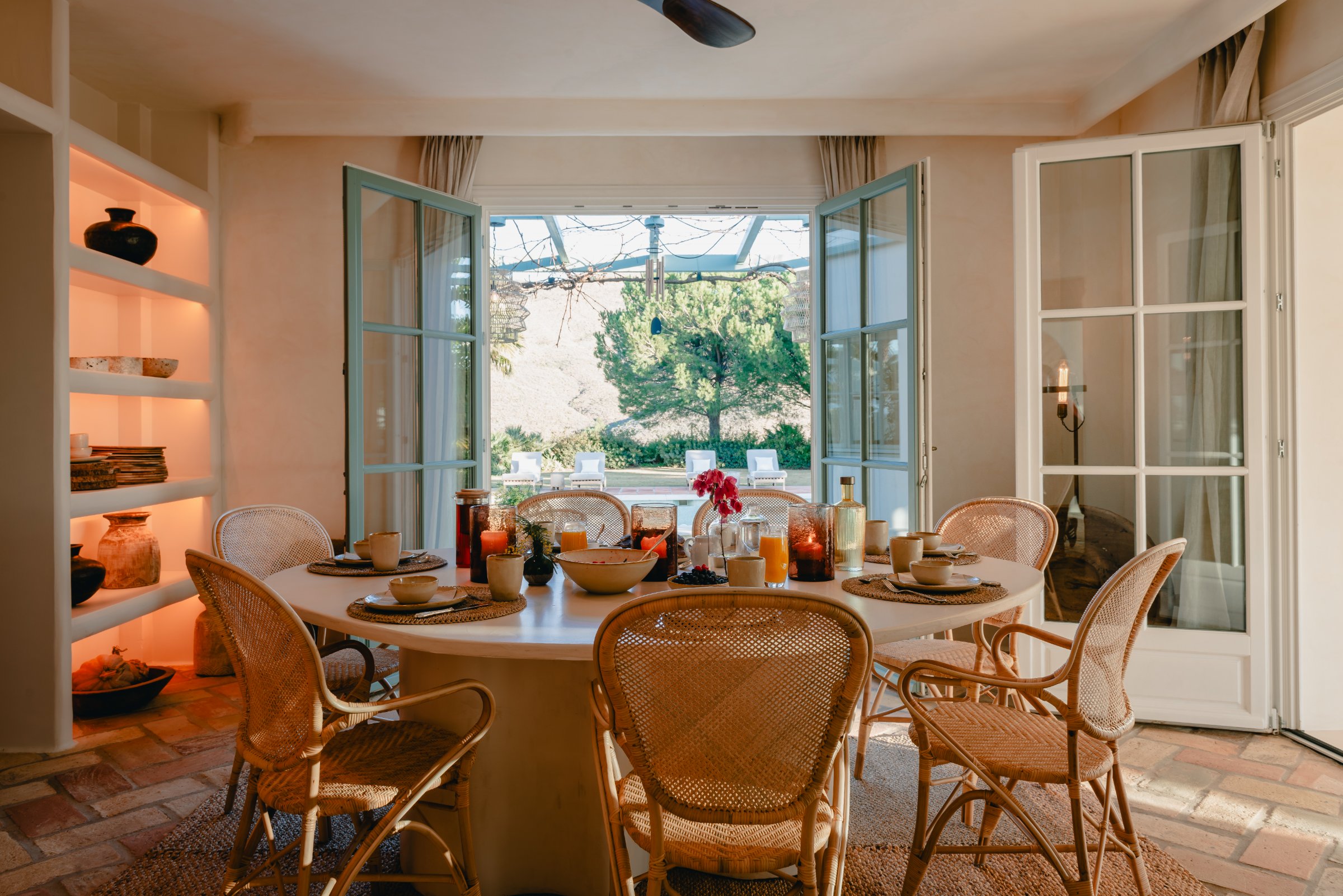 Viluz interior dining room — wicker pendants, marble tables, garden windows
