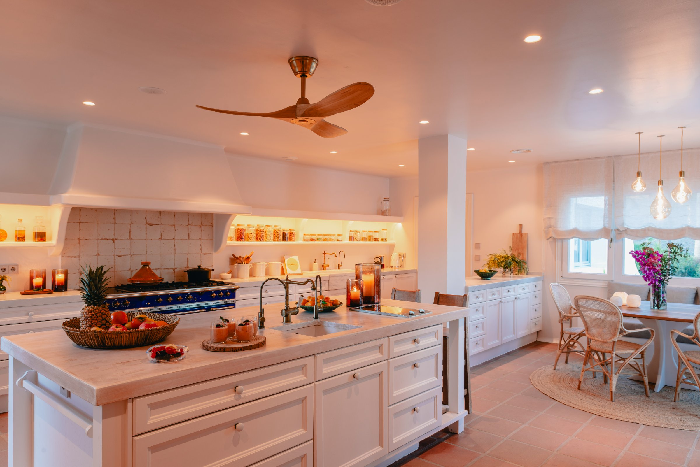 The Viluz kitchen — blue Lacanche range, amber lighting, fruit bowl