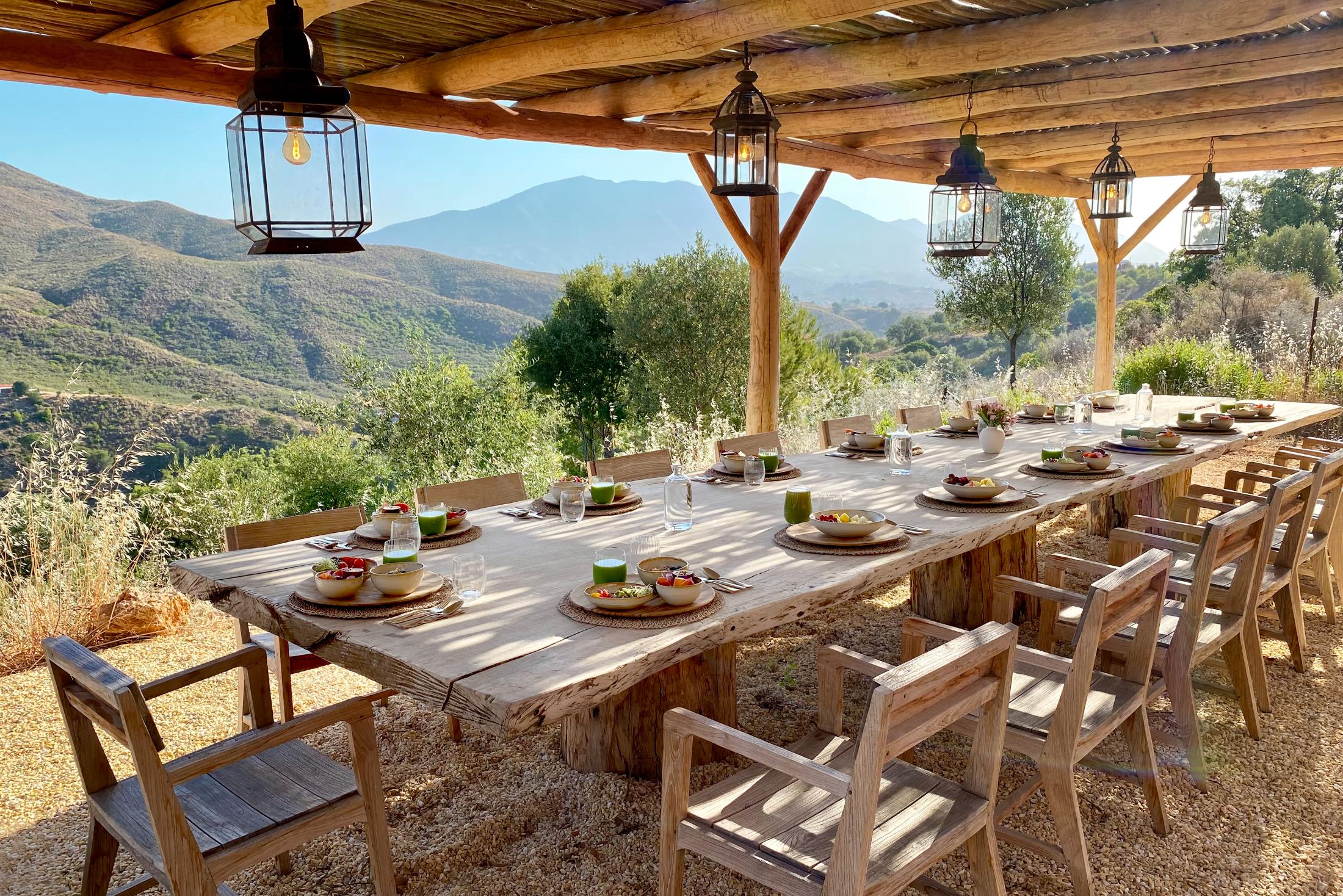 Outdoor pergola dining table with green smoothies, mountain view