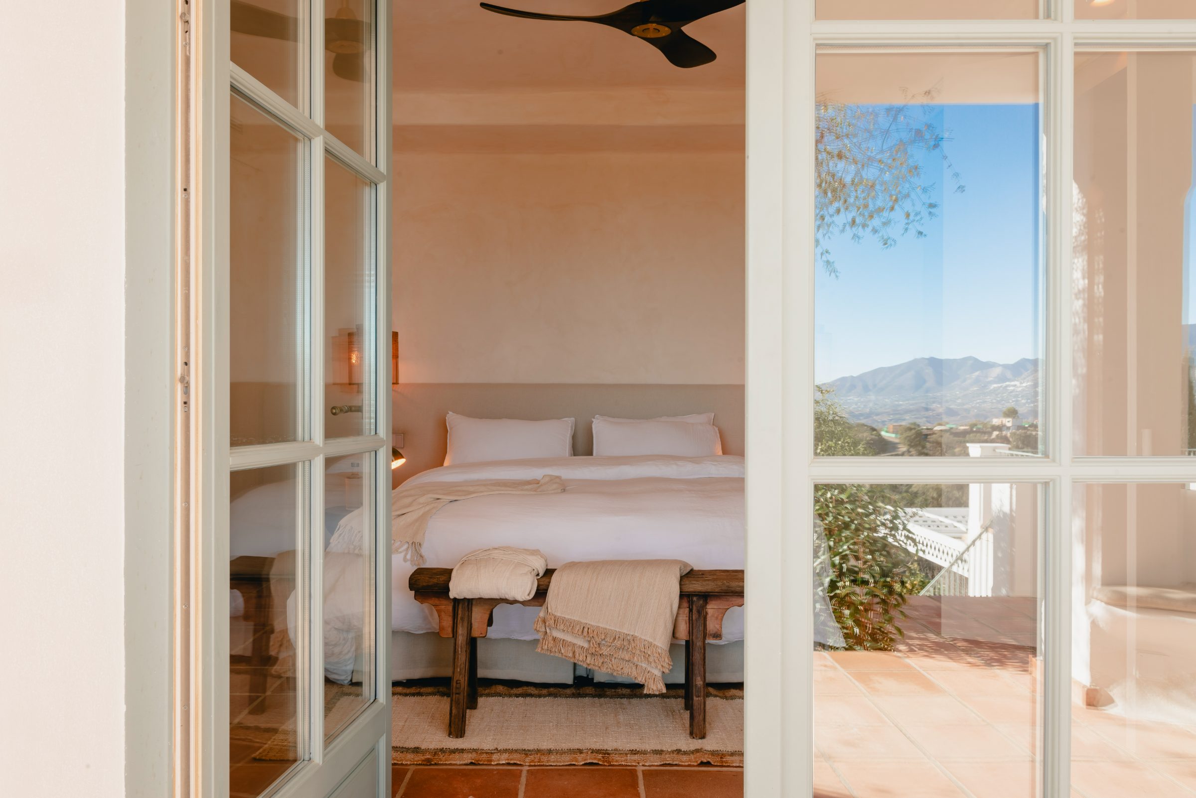 Open French doors looking out through ancient fig tree to the mountains